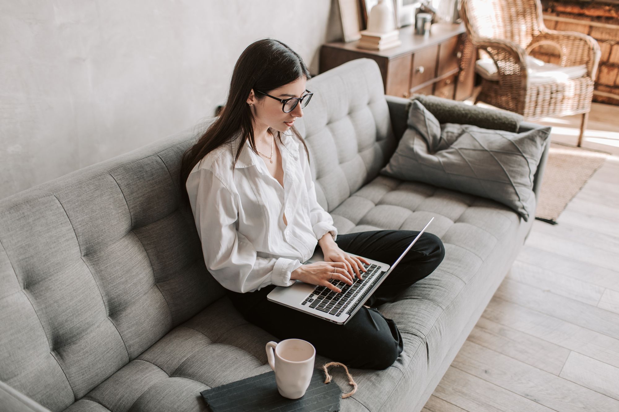 Woman using a laptop on a sofa at home
